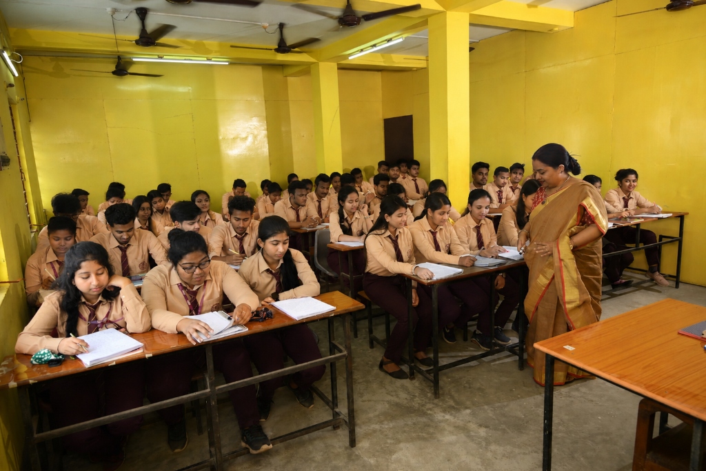 Teacher guiding students in classroom at St. Theresa's